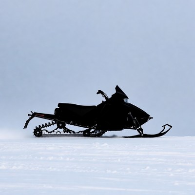Black snowmobile on snowy landscape
