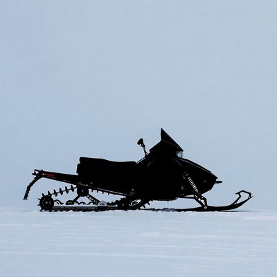 Black snowmobile silhouette on snow