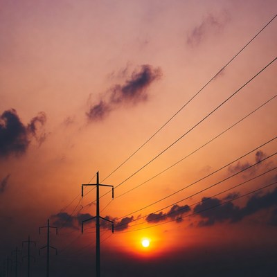 Power lines silhouetted against sunset