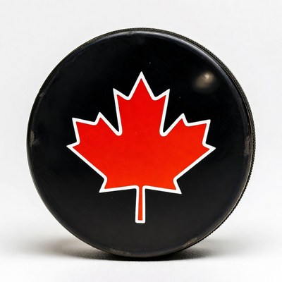 Black hockey puck with red maple leaf