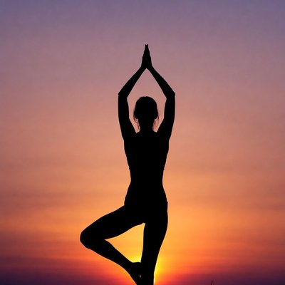 Woman in tree pose yoga silhouette sunset