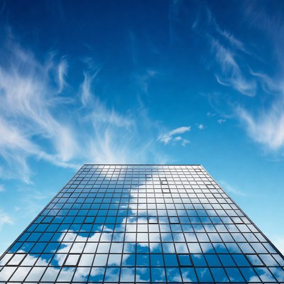 Glass Skyscraper Reflecting Blue Sky Clouds
