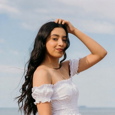 Latina woman hand on head beach