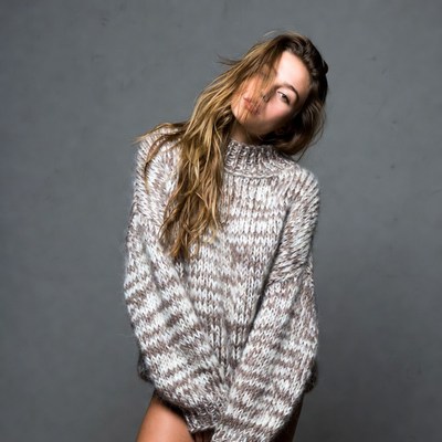 Woman in striped sweater posing sideways