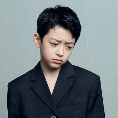 Asian boy in suit pouting