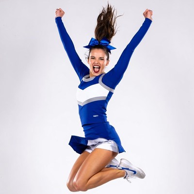 Cheerleader jumping with arms raised