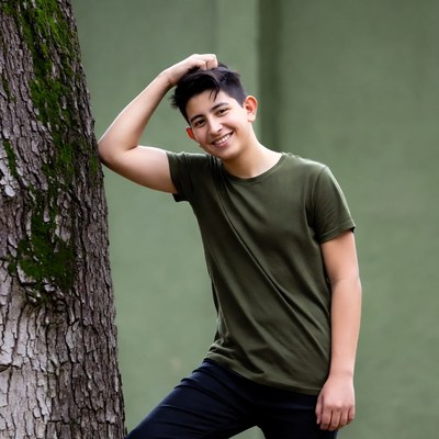 Teen boy leaning against mossy tree