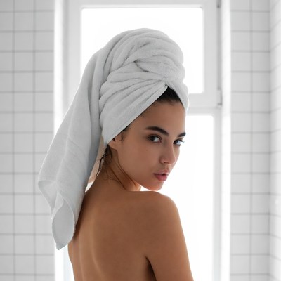 Woman with towel on head in bathroom
