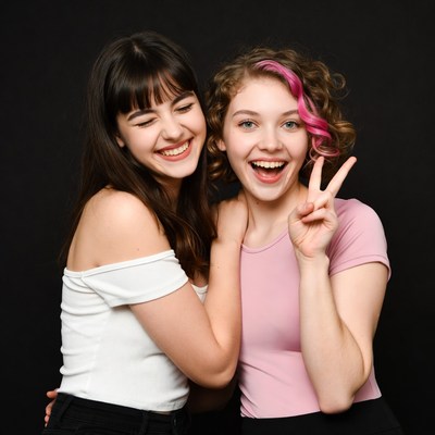 Two smiling girls making peace sign