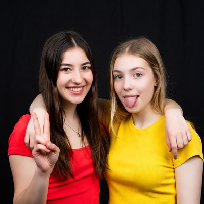 Two girls sticking tongue peace sign