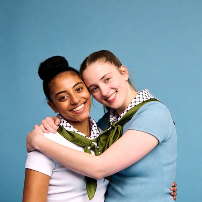 Two smiling girls hugging with scarves