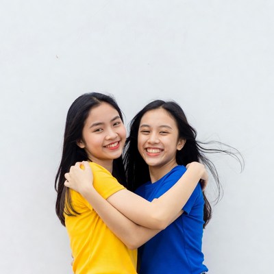 Two Asian girls hugging in t-shirts