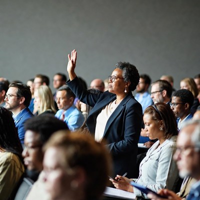 African-American woman raising hand in meeting