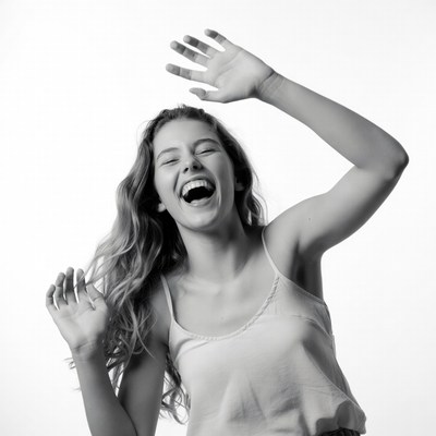 Young woman laughing with arms raised