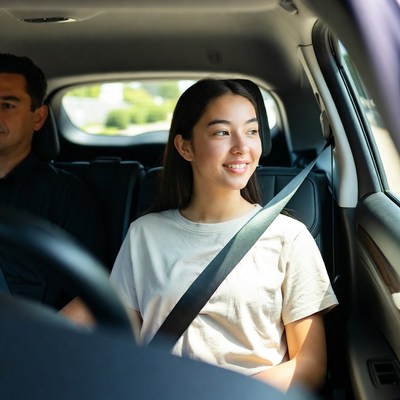 Asian girl smiling in car with dad