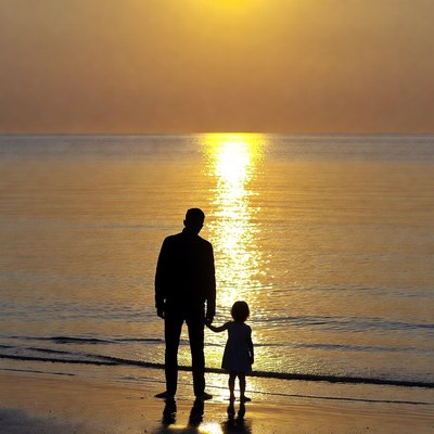 Father and daughter silhouette at sunset beach