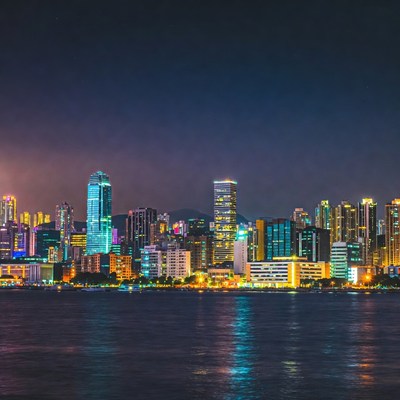 Vibrant City Skyline Over Water at Night