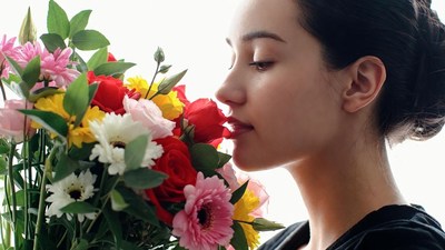 Asian woman smelling colorful bouquet