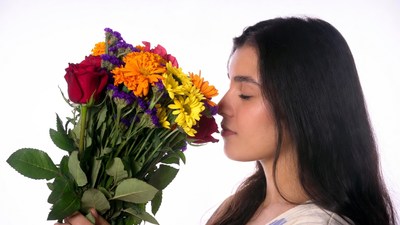 Asian woman smelling colorful bouquet
