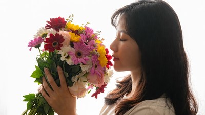 Asian woman smelling colorful bouquet