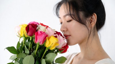 Asian woman smelling colorful roses