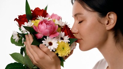 Asian woman smelling colorful bouquet