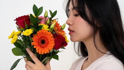 Asian woman smelling colorful bouquet