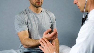 Doctor examining man's wrist