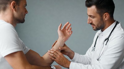 Doctor examining man's wrist