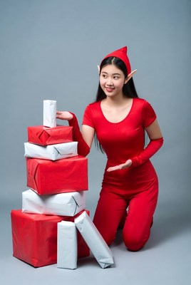 Asian girl in elf costume with gift stack