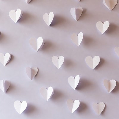 White paper hearts on purple background