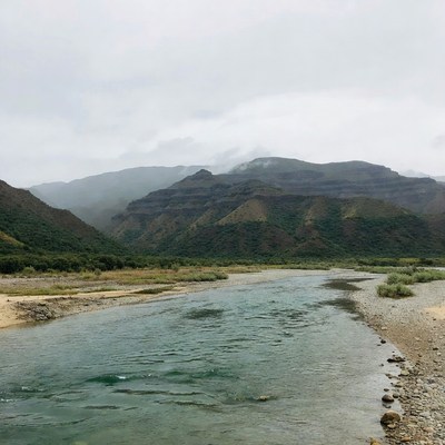 River flowing through layered mountains