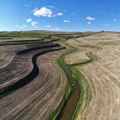 Winding river through contoured farmland