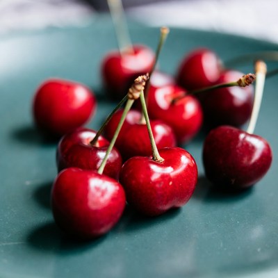 Red Cherries on Teal Plate