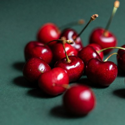 Fresh red cherries on green background