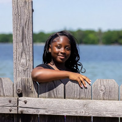 Smiling African-American girl leaning on wooden fence