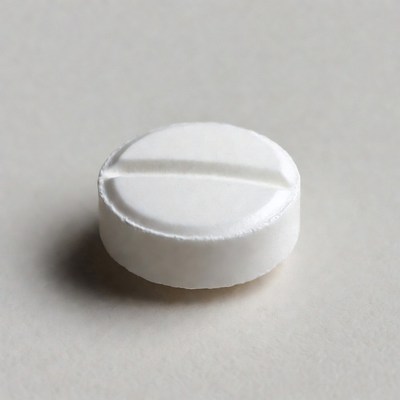 White round pill on gray surface