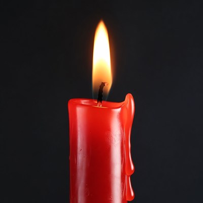 Red Burning Candle on Black Background