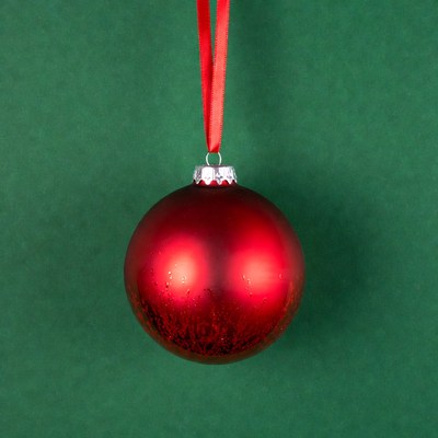 Red Christmas ornament hanging on ribbon