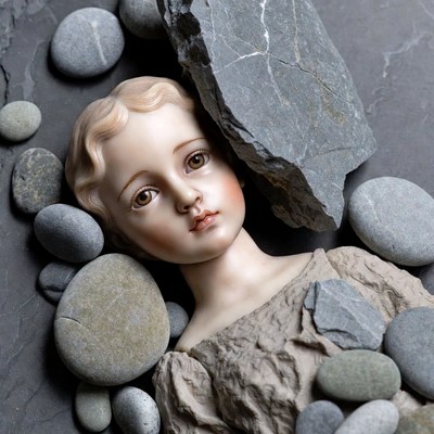 Porcelain Doll Among Gray Rocks