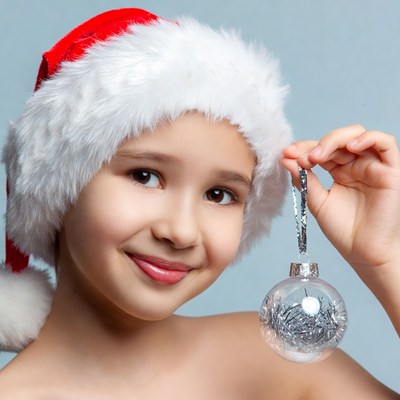 Asian girl holding silver Christmas ornament