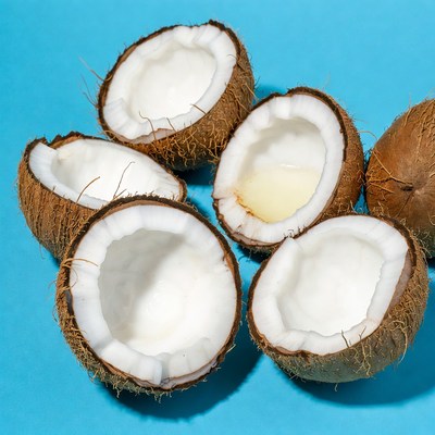 Fresh split coconuts on blue background