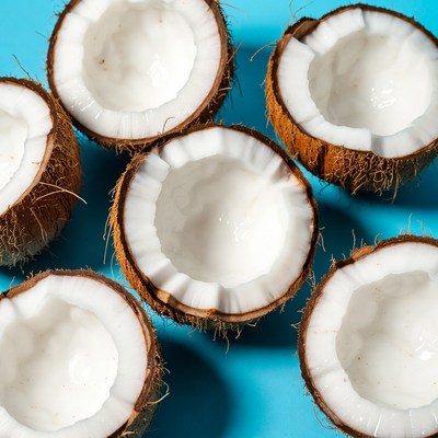 Fresh halved coconuts on blue background