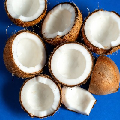 Fresh halved coconuts on blue background
