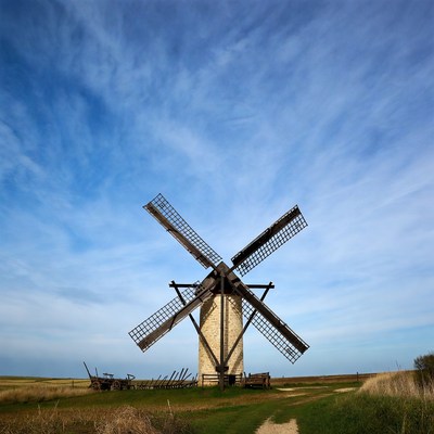 Windmill in field under blue sky