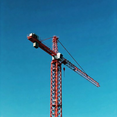 Red Tower Crane Against Blue Sky