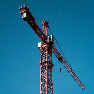 Red Construction Crane Against Blue Sky