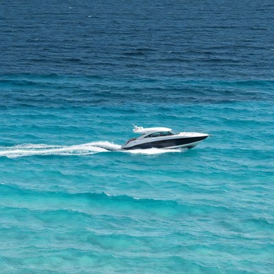 White speedboat cruising turquoise ocean