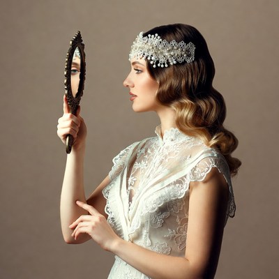 Woman gazing into ornate mirror