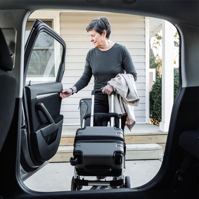 Woman unloading suitcases from car
